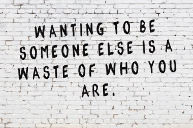 Boyalı siyah motivasyonel alıntı yazıtı ile beyaz tuğla duvar