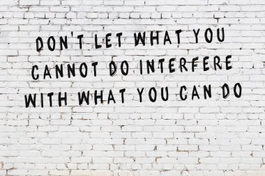 Boyalı siyah motivasyonel alıntı yazıtı ile beyaz tuğla duvar