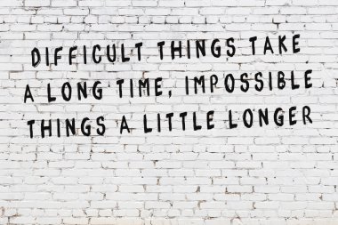 Boyalı siyah motivasyonel alıntı yazıtı ile beyaz tuğla duvar