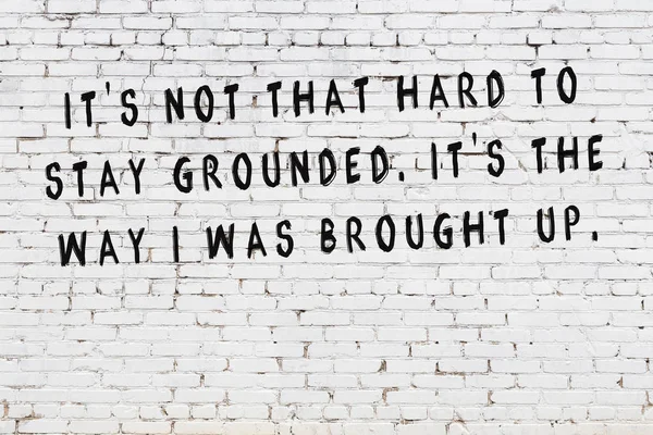 Біла цегляна стіна з пофарбованим чорним мотиваційним написом цитати — стокове фото