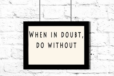 Beyaz tuğla duvara asılı bilge teklif ile siyah çerçeve