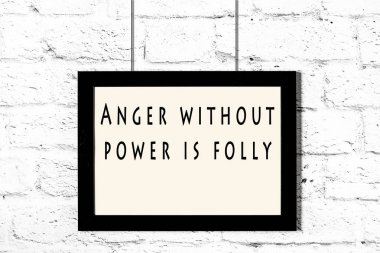 Beyaz tuğla duvara asılı bilge teklif ile siyah çerçeve