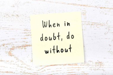 Ahşap duvara el yazısı bilge alıntı ile sarı yapışkan not 