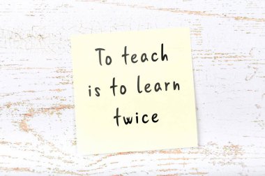 Ahşap duvara el yazısı bilge alıntı ile sarı yapışkan not 