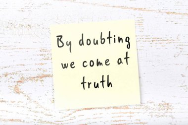 Ahşap duvara el yazısı bilge alıntı ile sarı yapışkan not 