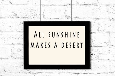 Beyaz tuğla duvara asılı bilge teklif ile siyah çerçeve