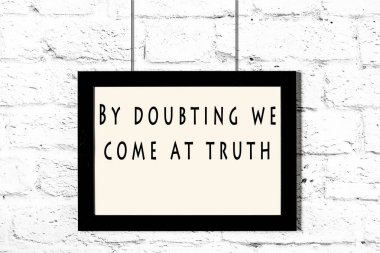 Beyaz tuğla duvara asılı bilge teklif ile siyah çerçeve