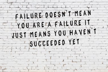 Boyalı siyah motivasyonel alıntı yazıtı ile beyaz tuğla duvar