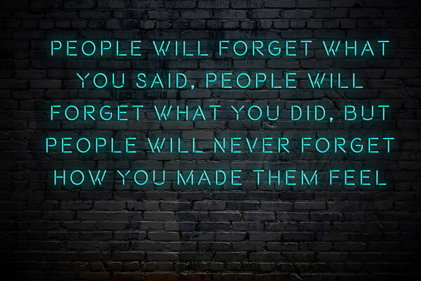 Neon inscription of positive wise motivational quote against brick wall 