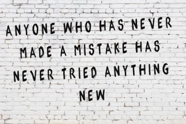 Boyalı siyah motivasyonel alıntı yazıtı ile beyaz tuğla duvar