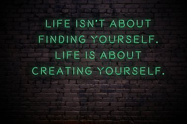 Karanlıkta tuğla duvarda bilge alıntı ile Neon işareti