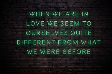 Karanlıkta tuğla duvarda bilge alıntı ile Neon işareti