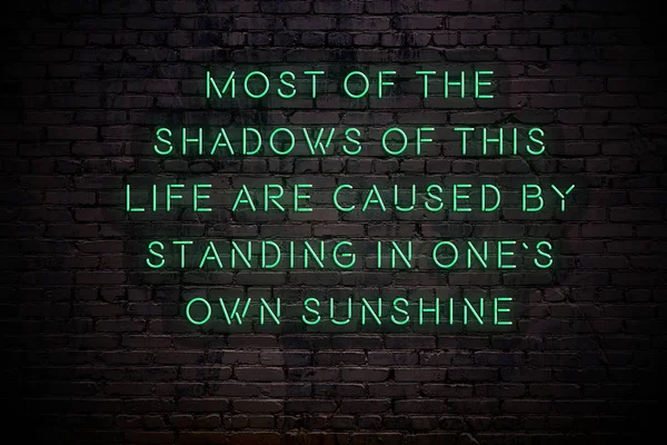 Sinal de néon com sábia citação na parede de tijolos na escuridão — Fotografia de Stock