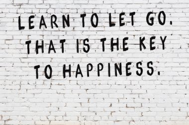 Beyaz tuğla duvar arkaplanına siyah düşünceli bir yazı.