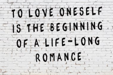 Beyaz tuğla duvar arkaplanına siyah düşünceli bir yazı.