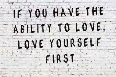 Beyaz tuğla duvar arkaplanına siyah düşünceli bir yazı.