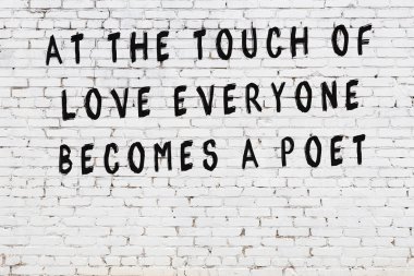 Beyaz tuğla duvar arkaplanına siyah düşünceli bir yazı.