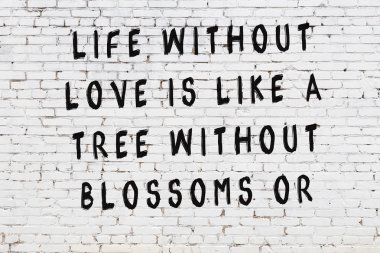 Beyaz tuğla duvar arkaplanına siyah düşünceli bir yazı.