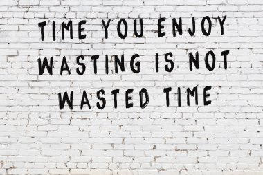 Beyaz tuğla duvar arkaplanına siyah düşünceli bir yazı.