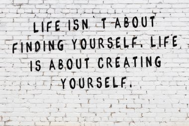 Bilgece alıntıların yazılı olduğu siyah boyanmış beyaz tuğla duvar