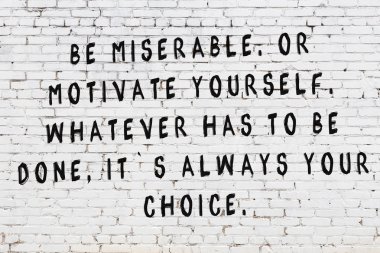 Bilgece alıntıların yazılı olduğu siyah boyanmış beyaz tuğla duvar