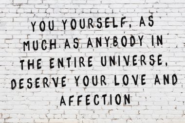 Bilgece alıntıların yazılı olduğu siyah boyanmış beyaz tuğla duvar