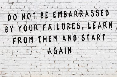 Bilgece alıntıların yazılı olduğu siyah boyanmış beyaz tuğla duvar