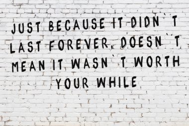 Bilgece alıntıların yazılı olduğu siyah boyanmış beyaz tuğla duvar