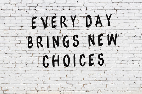 White brick wall with black painted inscription of sensible wise quote on it