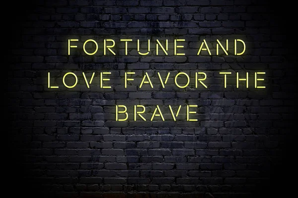 Neon inscription of sensible quote against brick wall at night