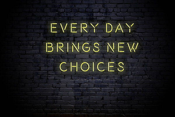 Neon inscription of sensible quote against brick wall at night