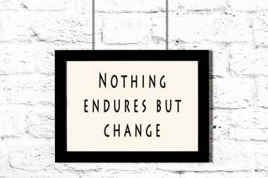 Beyaz tuğla duvara asılı bilge teklif ile siyah çerçeve