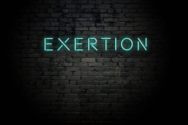 Highlighted brick wall with neon inscription exertion