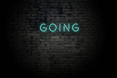 Highlighted brick wall with neon inscription going