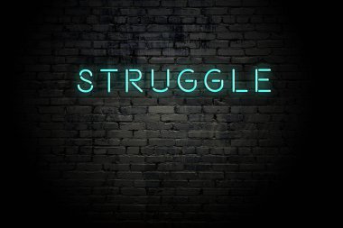 Neon yazıt mücadele ile vurgulu tuğla duvar