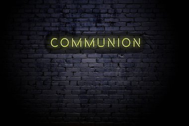 Neon yazıtlı komünyon ile vurgulanmış tuğla duvar