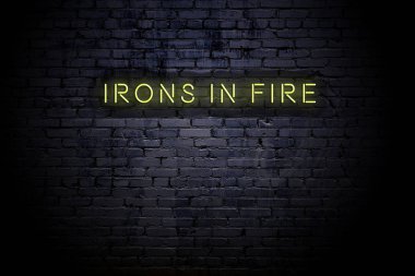 Yangında neon yazıtlı ütüler ile vurgulanmış tuğla duvar