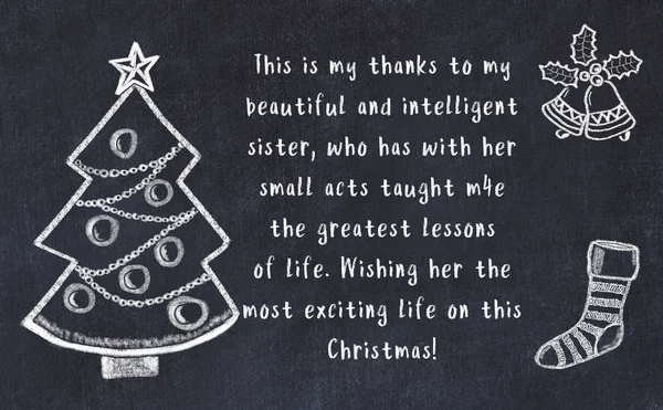 Drawing of christmas tree and handwritten greetings on black chalkboard