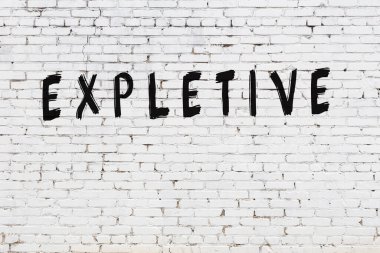 Üzerinde siyah boya yazıları olan beyaz duvar.