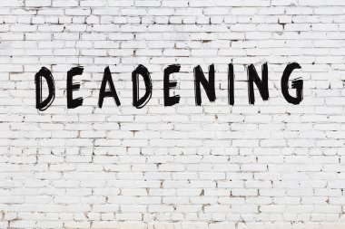 Üzerinde siyah boya yazıları olan beyaz bir duvar.