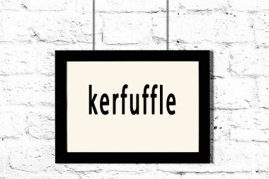 Beyaz tuğla duvarda asılı siyah çerçeve.