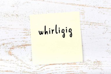 Tahta duvarda sarı yapışkan bir not, el yazısıyla yazılmış bir girdap.