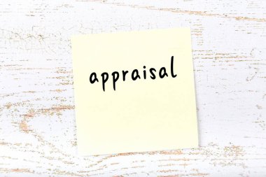 Tahta duvardaki sarı yapışkan notta elle yazılmış sözcük değerlendirmesi var.