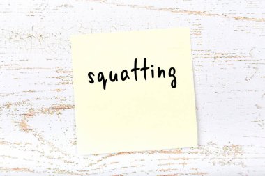 Sarı yapışkan not ahşap duvarda el yazısıyla yazılmış.