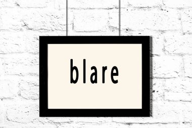 Beyaz tuğla duvarda asılı duran siyah çerçeve.