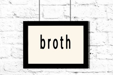 Beyaz tuğla duvarda asılı siyah çerçeve.