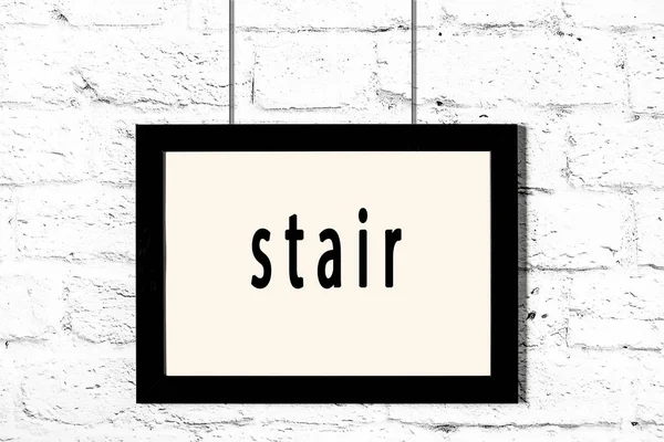 Fekete keret lóg fehér téglafal felirat lépcső — Stock Fotó