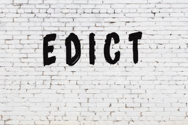 Beyaz tuğla duvara yazılmış bir ferman.