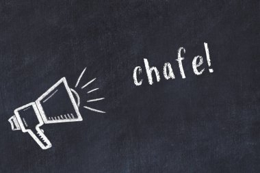Tebeşir hoparlörü ve siyah karatahtaya yazılmış yazı.