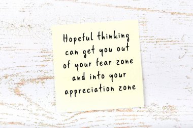 Ahşap duvardaki sarı yapışkan notta bilgece bir alıntı var.